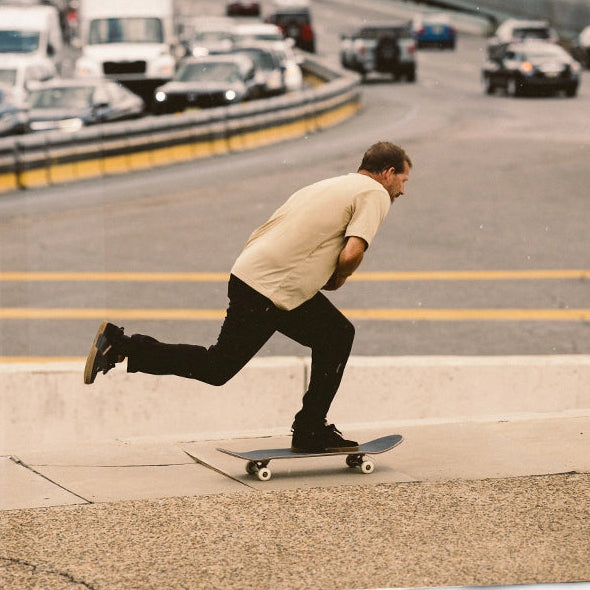 A three-panel collage showing a man wearing black skate shoes with tan and brown gum soles, including a close-up of the shoes, a photo of him sitting in a car window, and a full-body shot of him skateboarding outdoors.