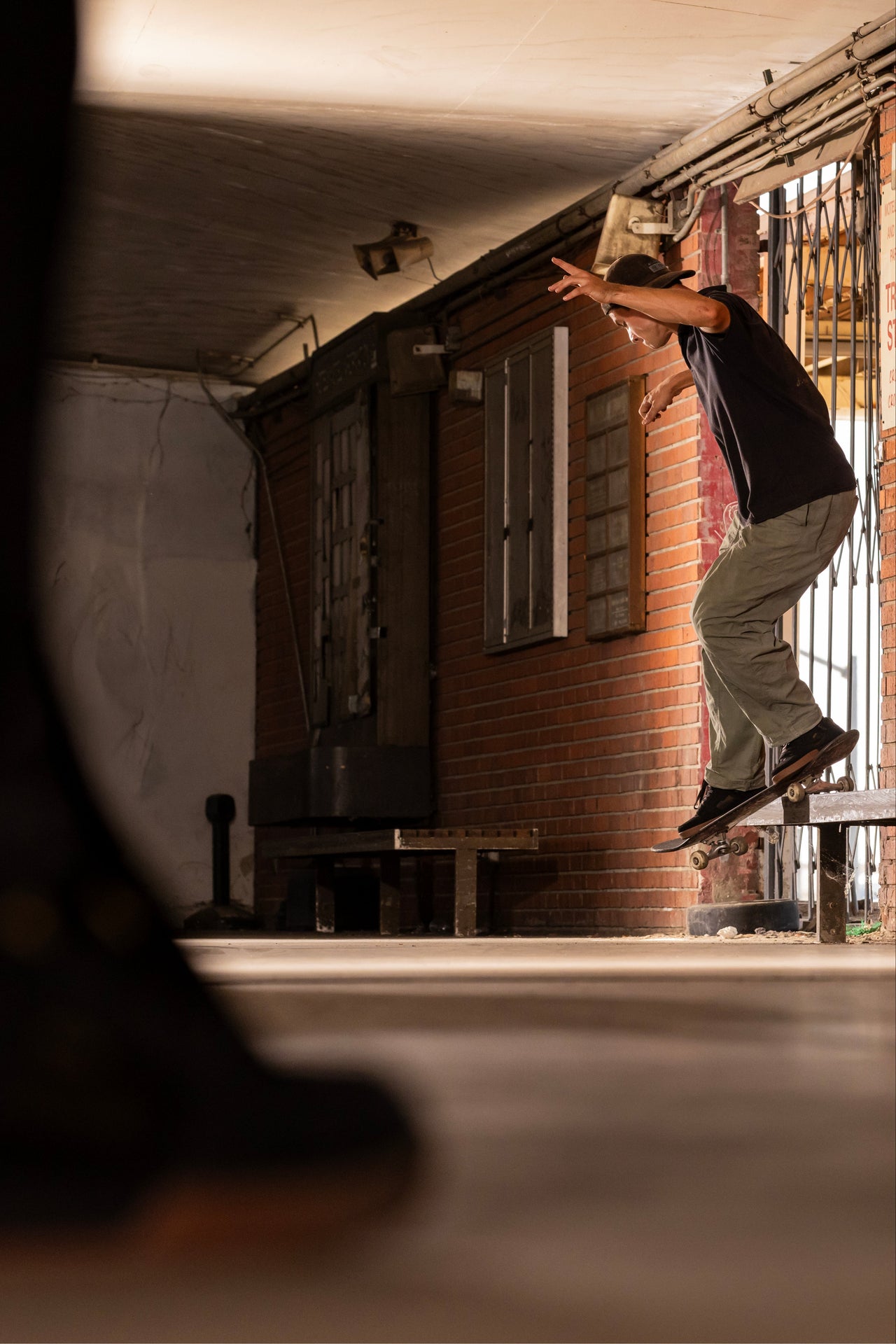 Person skateboarding in an urban setting with a brick building in the background