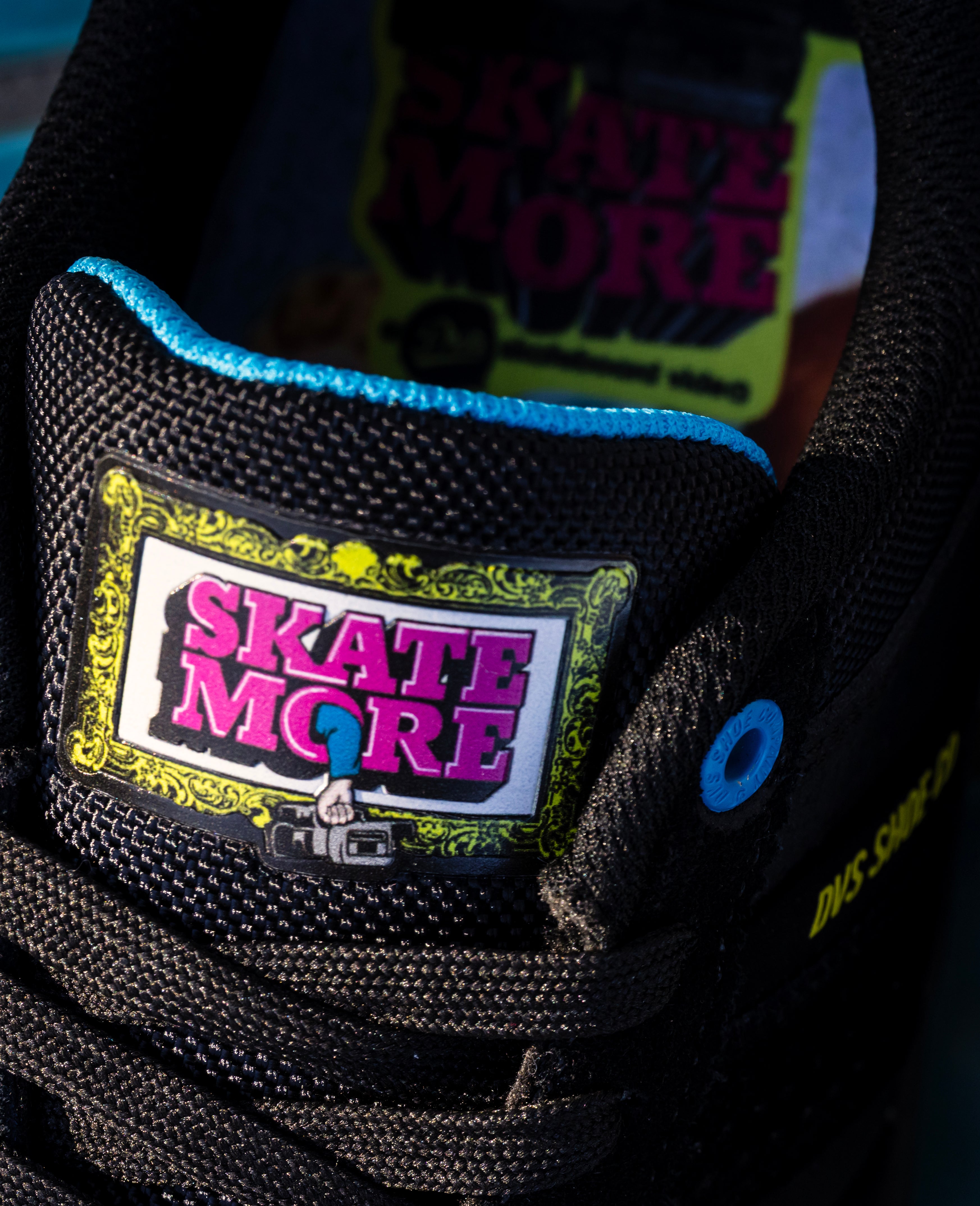 Close-up of a shoe with 'Skate More' branding on a dark background