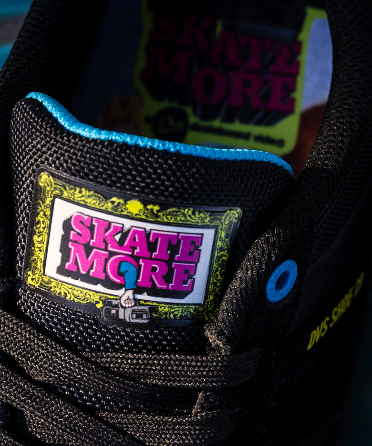Close-up of a shoe with 'Skate More' branding on a dark background