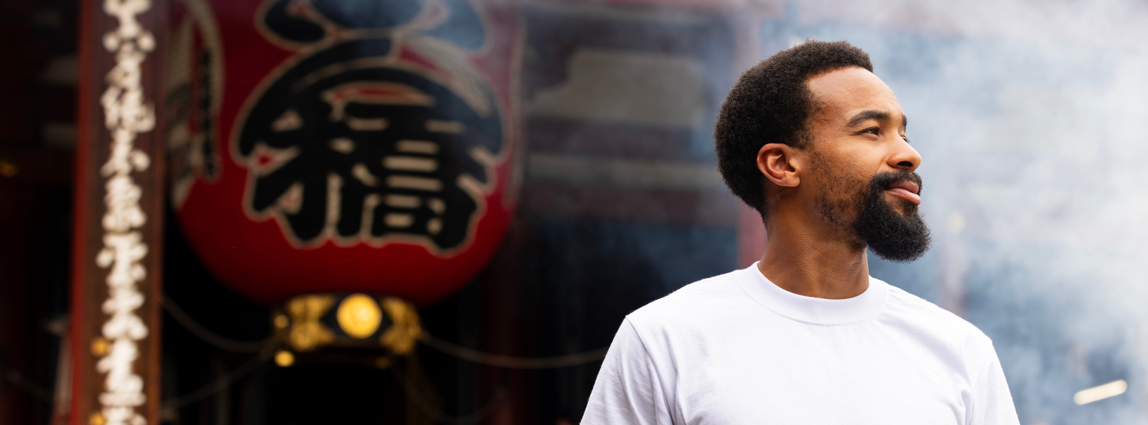 Man standing in front of a traditional Japanese lantern with blurred background