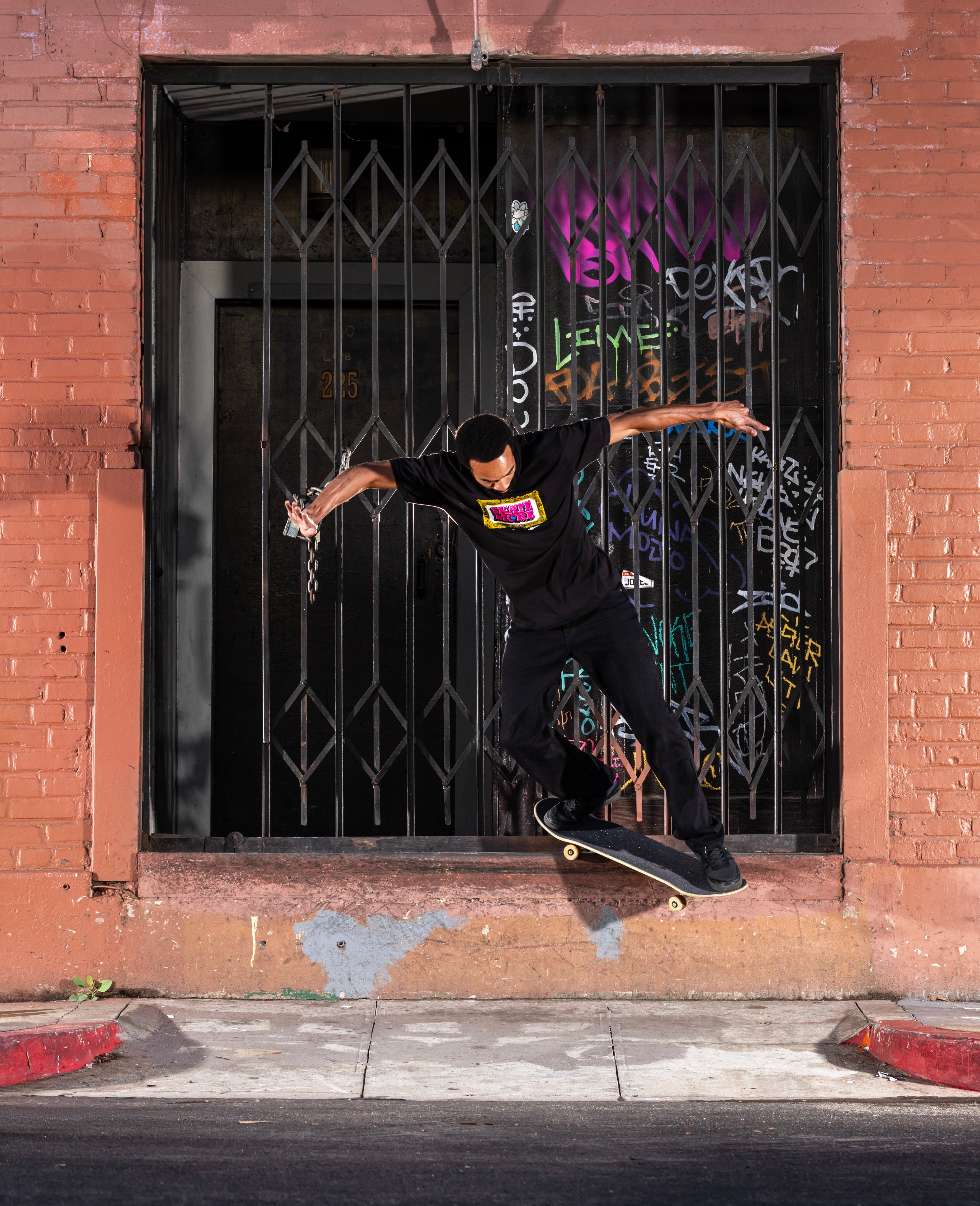 Person skateboarding in front of a brick wall with a barred window