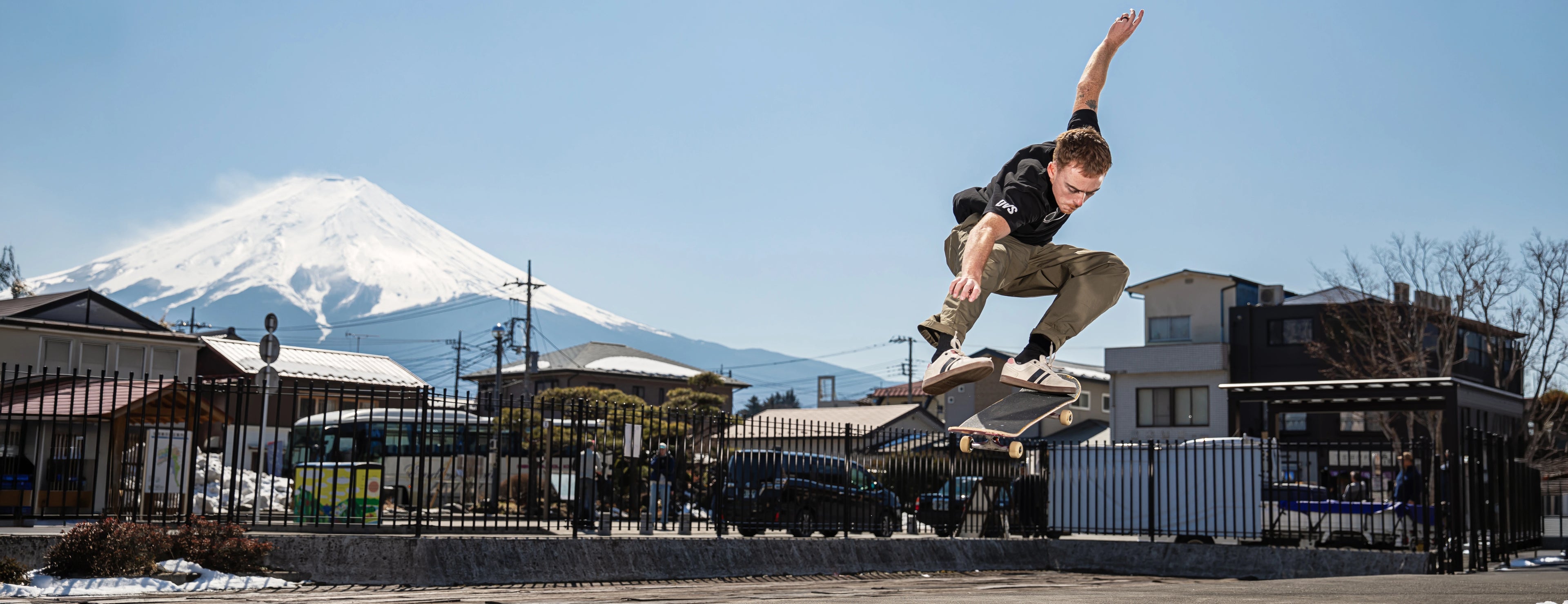 Person skateboarding in an urban setting with a mountain in the background
